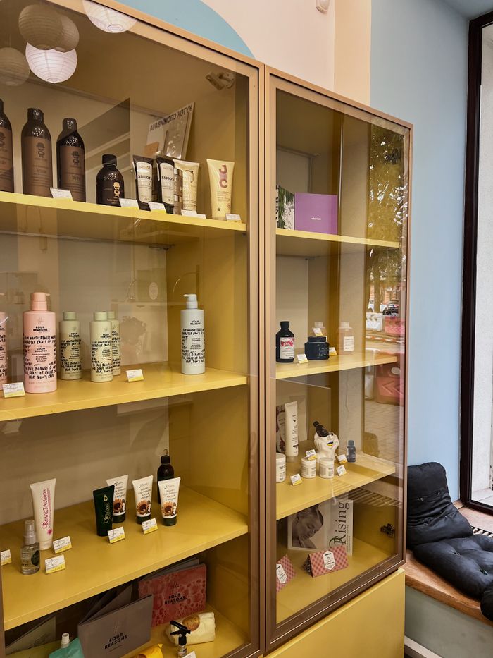 Explore a colorful array of cosmetics elegantly showcased on vibrant yellow shelving indoors.