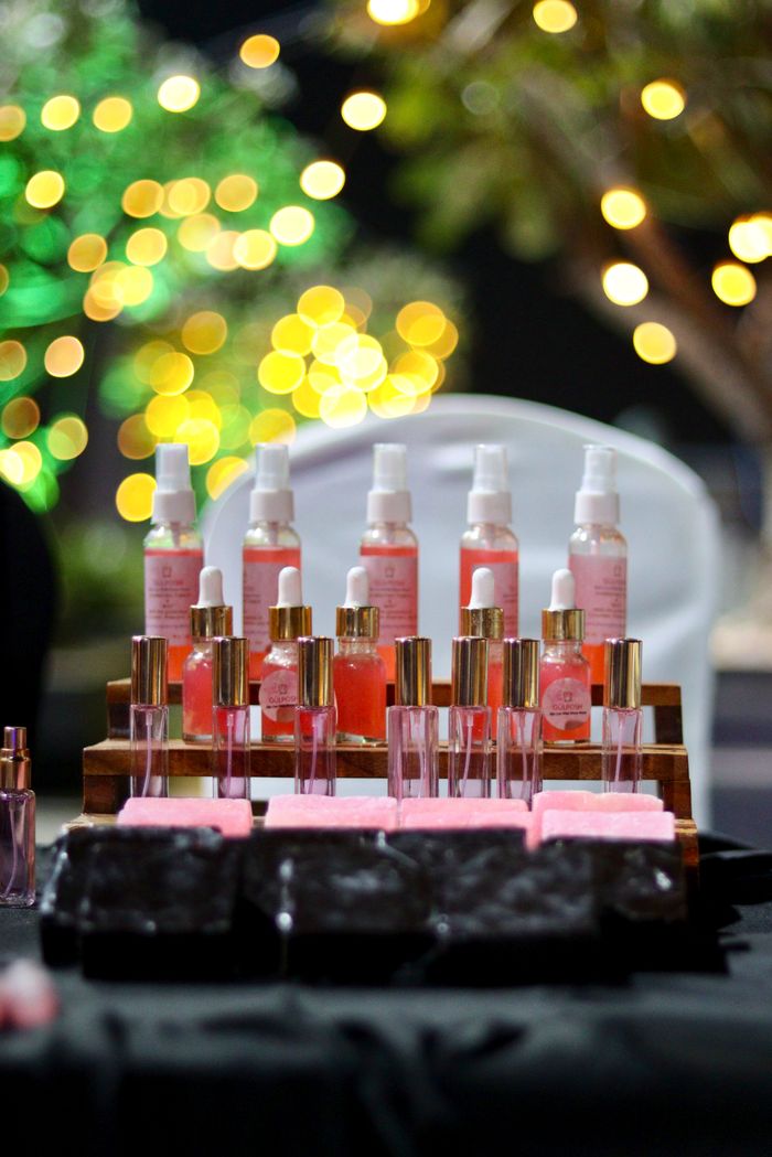 Beautiful arrangement of pink skincare bottles and soaps with bokeh lights background, perfect for beauty promotions.